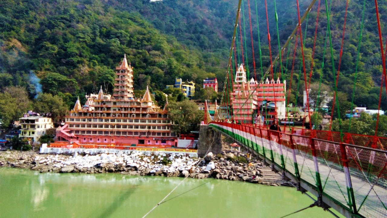 Lakshman Jhula bridge and Tera Manzil Temple on the banks of River Ganga in Rishikesh, Uttarakhand