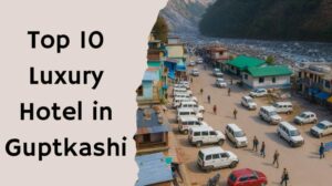 Aerial view of Guptkashi town with cars parked along the road near the mountains, representing luxury hotels in Guptkashi.