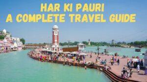 Devotees and tourists at Har Ki Pauri ghat in Haridwar during the day with the iconic clock tower beside the Ganga River.