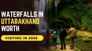 Tourists enjoying a scenic waterfall surrounded by lush greenery in Uttarakhand, India.